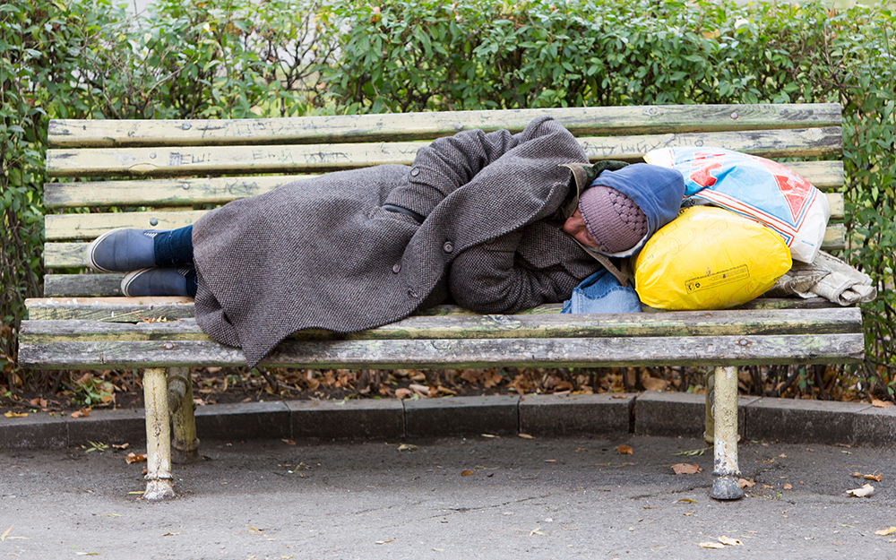 Homeless person sleeping on bench