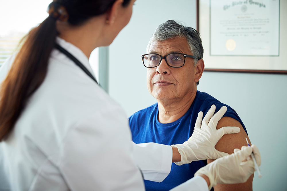 Man receiving vaccine from doctor